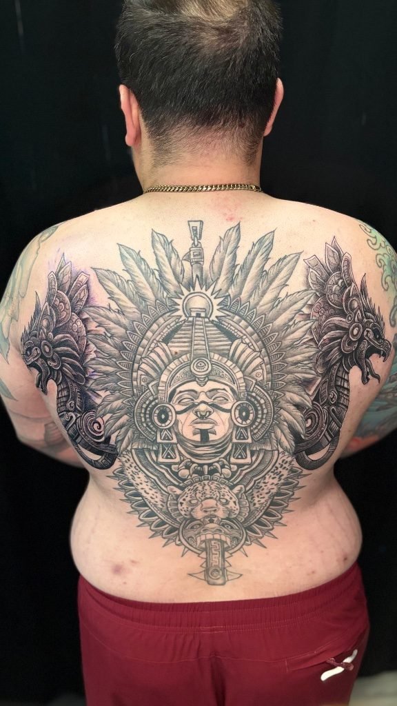 Full back coverage piece in mexica blackwork style